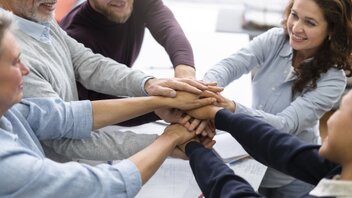 close-up-happy-people-holding-hands-together